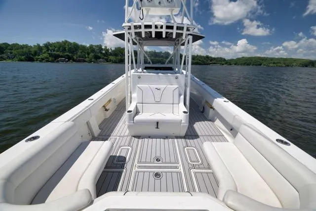 Slide: The Image of 2016 SeaVee 390 boat with spacious deck, white seating, and scenic lake view. - 55