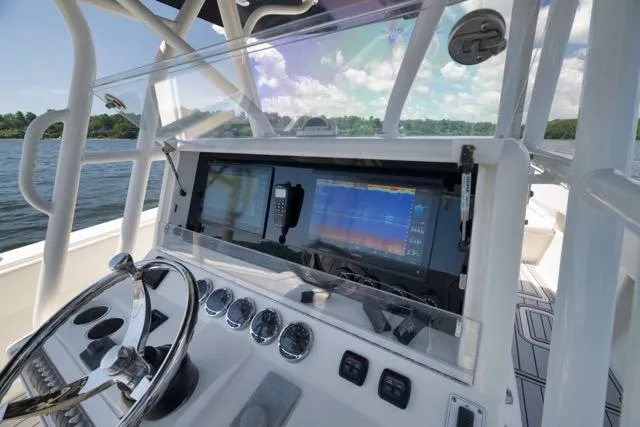 Slide: The Image of 2016 SeaVee 390 boat dashboard with navigation screens and steering wheel on open water. - 66