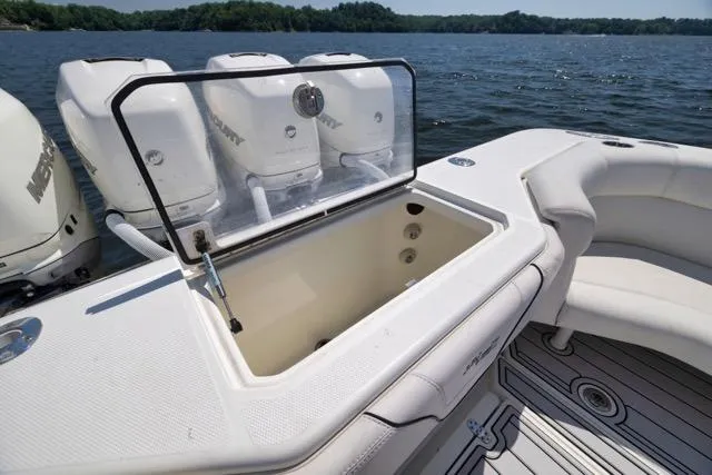 Slide: The Image of 2016 SeaVee 390 boat with open storage compartment and multiple outboard engines on a lake. - 49