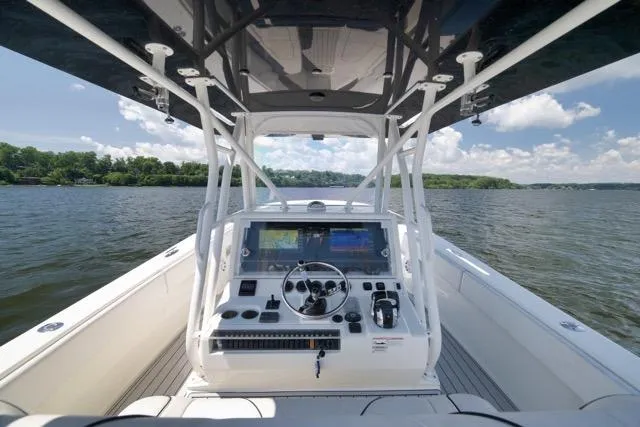 Slide: The Image of 2016 SeaVee 390 boat helm with navigation controls on a sunny day. - 63
