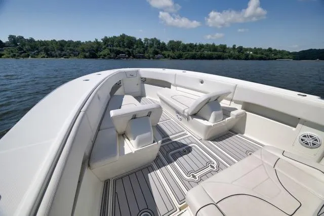 Slide: The Image of 2016 SeaVee 390 boat interior with seating, on a calm lake under a blue sky. - 33