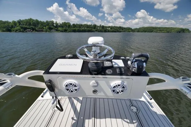 Slide: The Image of 2016 SeaVee 390 boat helm with Garmin system on a calm lake under blue skies. - 58