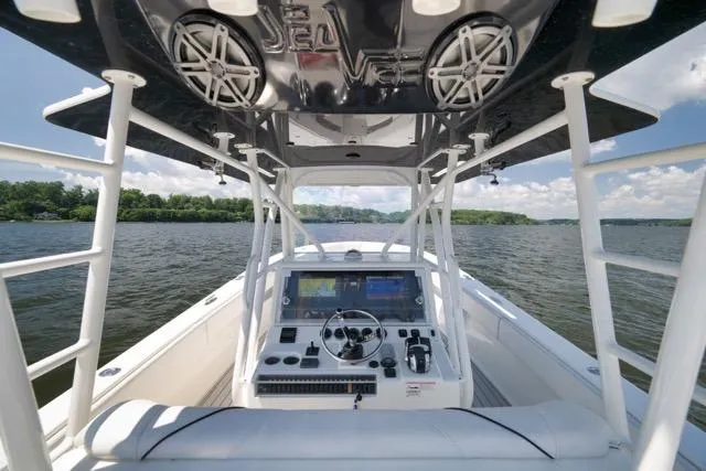 Slide: The Image of 2016 SeaVee 390 boat dashboard with navigation controls on a calm lake. - 64