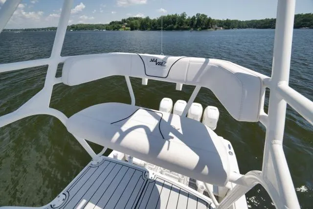Slide: The Image of 2016 SeaVee 390 boat with white seating, overlooking a serene lake view. - 60