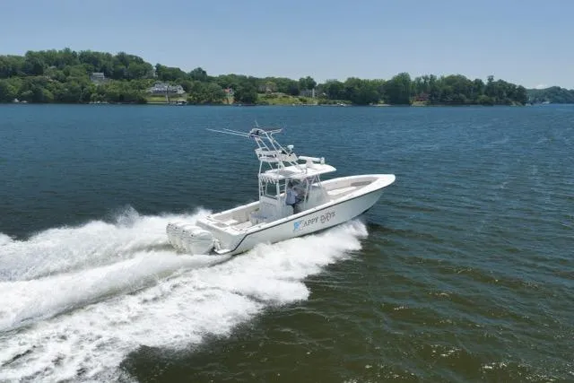 Slide: The Image of 2016 SeaVee 390 boat cruising on a lake with lush green shoreline. - 23