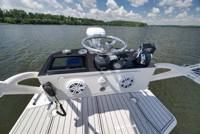 Slide: The Image of 2016 SeaVee 390 boat helm with steering wheel, controls, and navigation system on a sunny day. - 62
