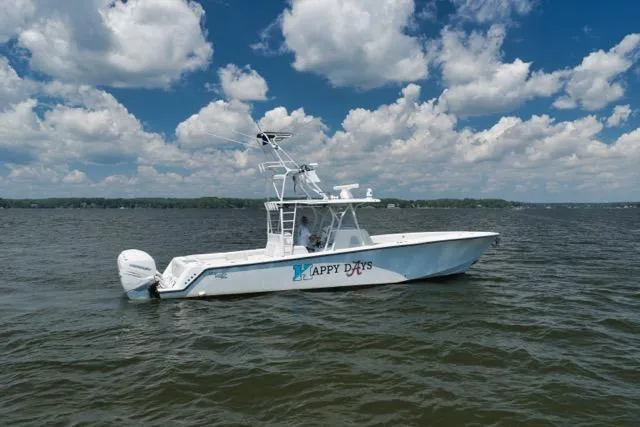 Slide: The Image of 2016 SeaVee 390 boat named "Happy Days" on a lake under a cloudy sky. - 12