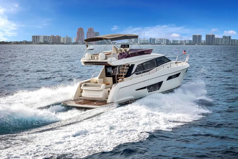 Slide: The Image of 2021 Ferretti Yachts 500 cruising on open water with city skyline in background. - 4