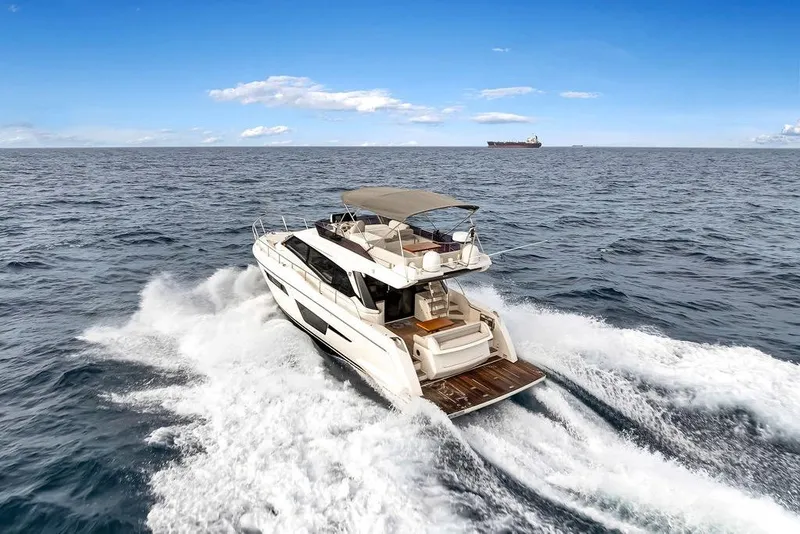 Slide: The Image of 2021 Ferretti Yachts 500 cruising on open sea under clear blue sky. - 8