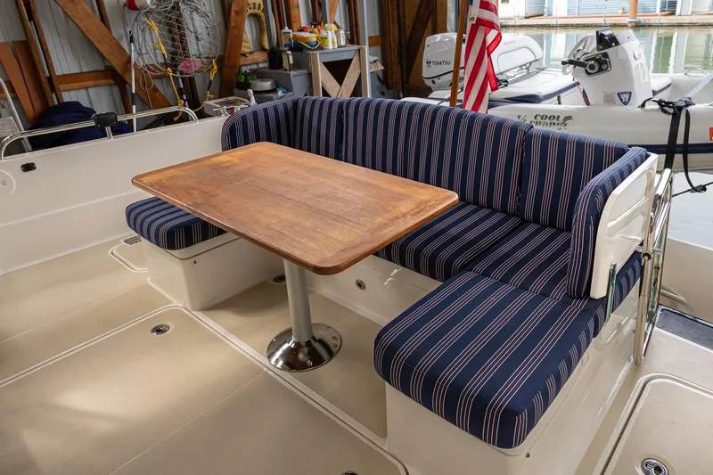 Slide: The Image of 2023 Sabre 45 Salon Express yacht interior with striped seating and wooden table. - 11