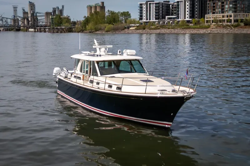 Slide: The Image of 2023 Sabre 45 Salon Express yacht cruising near urban waterfront buildings. - 2