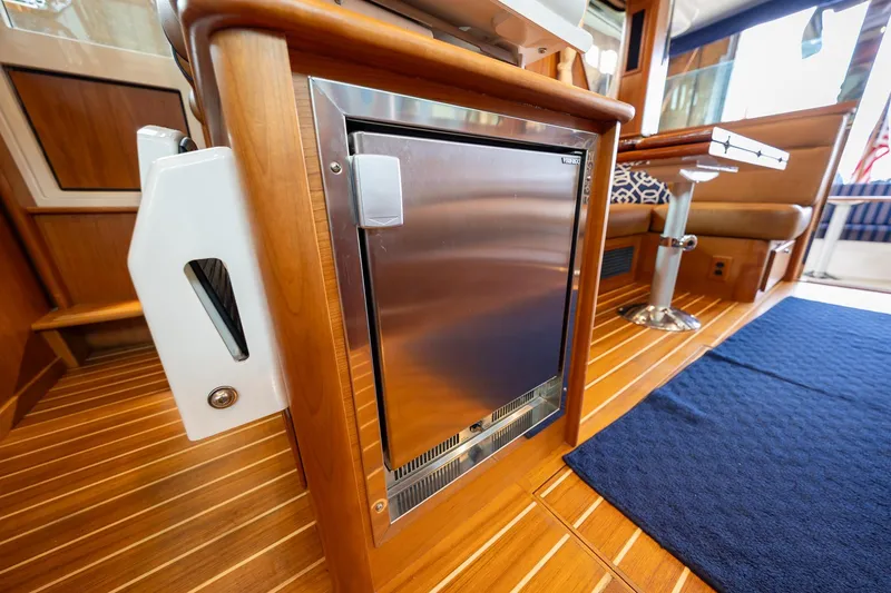 Slide: The Image of Interior of 2023 Sabre 45 Salon Express yacht with wooden flooring and stainless steel fridge. - 22