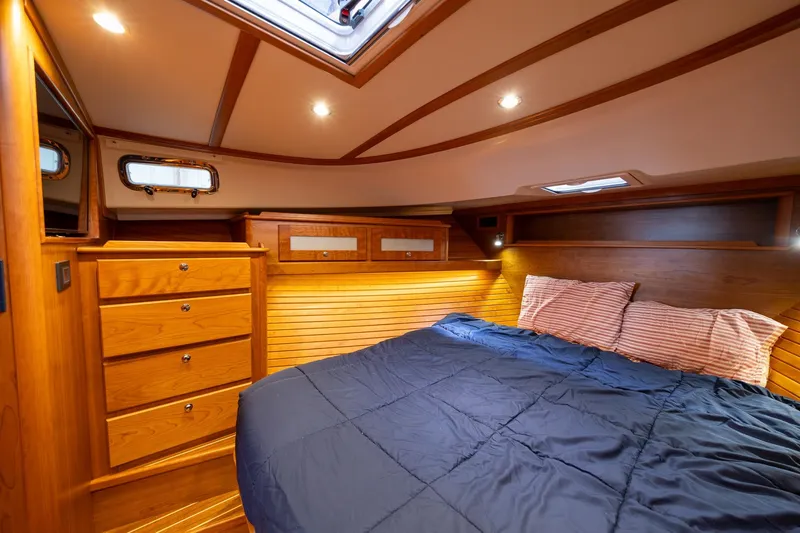 Slide: The Image of Luxurious 2023 Sabre 45 Salon Express cabin with wood finish and cozy bedding. - 30