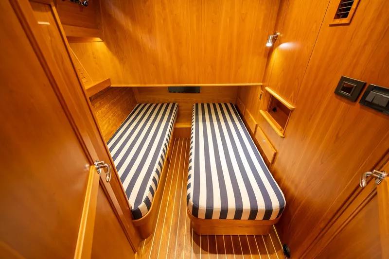 Slide: The Image of 2023 Sabre 45 Salon Express cabin with twin striped beds and wooden interior. - 34