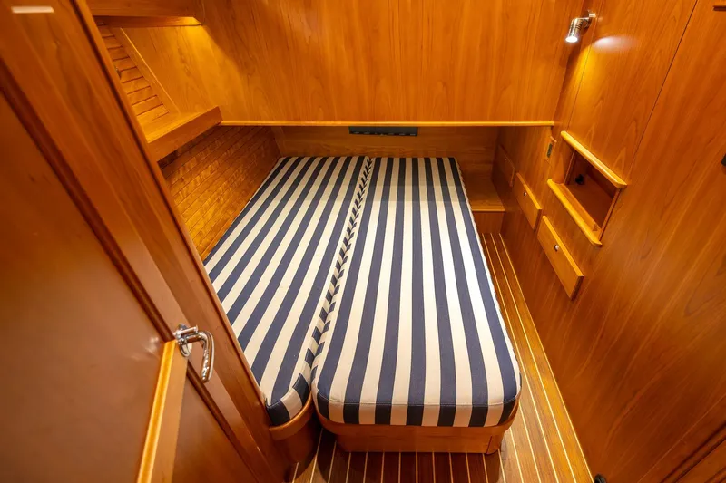 Slide: The Image of 2023 Sabre 45 Salon Express cabin with striped bedding and wooden interior. - 35