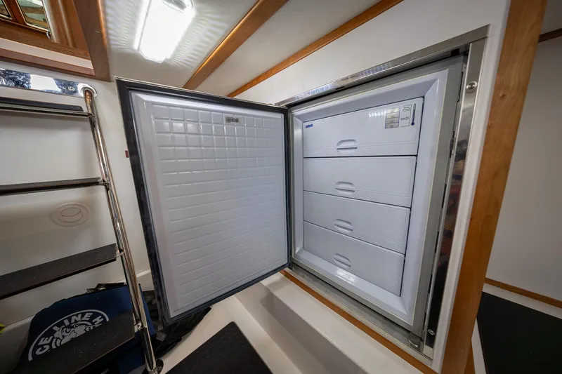 Slide: The Image of Open freezer compartment inside 2023 Sabre 45 Salon Express yacht, featuring four storage drawers. - 42