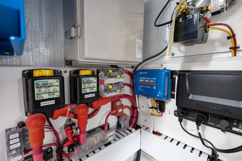 Slide: The Image of Electrical system components in a 2023 Sabre 45 Salon Express yacht, featuring inverters and controllers. - 57