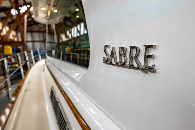 Slide: The Image of 2023 Sabre 45 Salon Express yacht in a boatyard, showcasing sleek design and branding. - 58