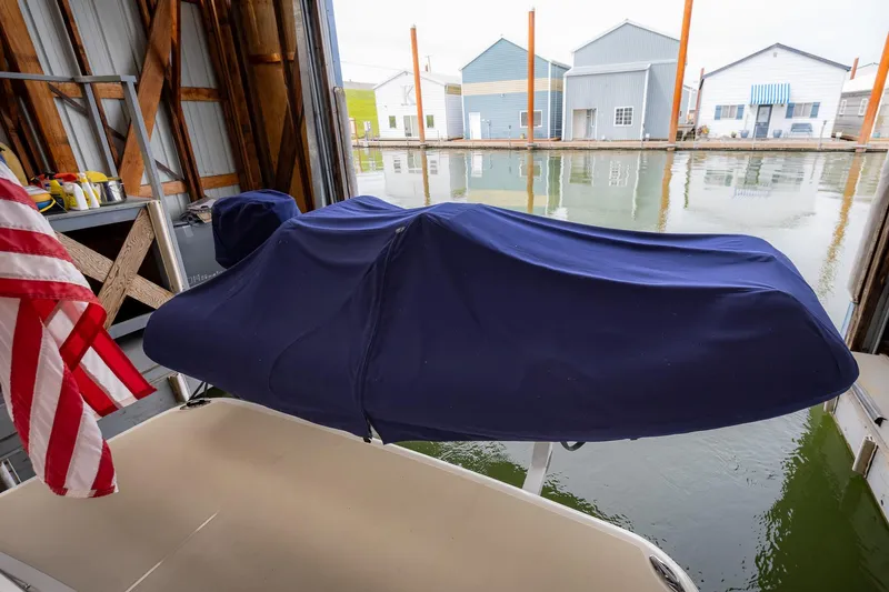 Slide: The Image of Covered Sabre 45 Salon Express boat in dock, 2023 model, with American flag nearby. - 64