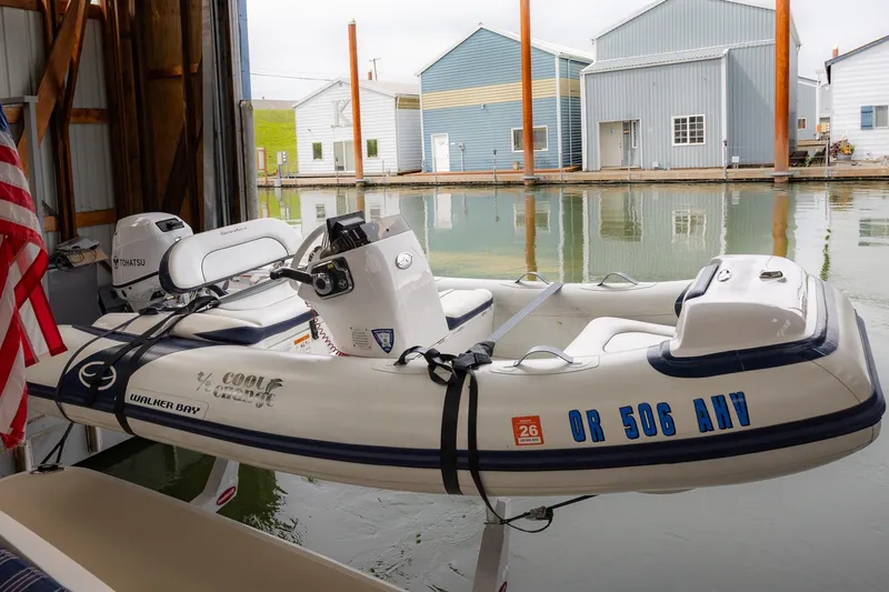 Slide: The Image of Inflatable boat docked in marina, featuring Tohatsu motor and American flag. - 65