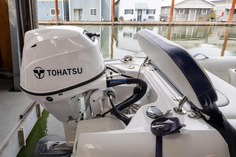Slide: The Image of Tohatsu outboard motor on 2023 Sabre 45 Salon Express boat, docked near waterfront homes. - 66