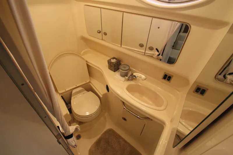 Slide: The Image of 2005 Sea Ray 340 Sundancer bathroom with sink, toilet, and mirrored cabinet. - 15