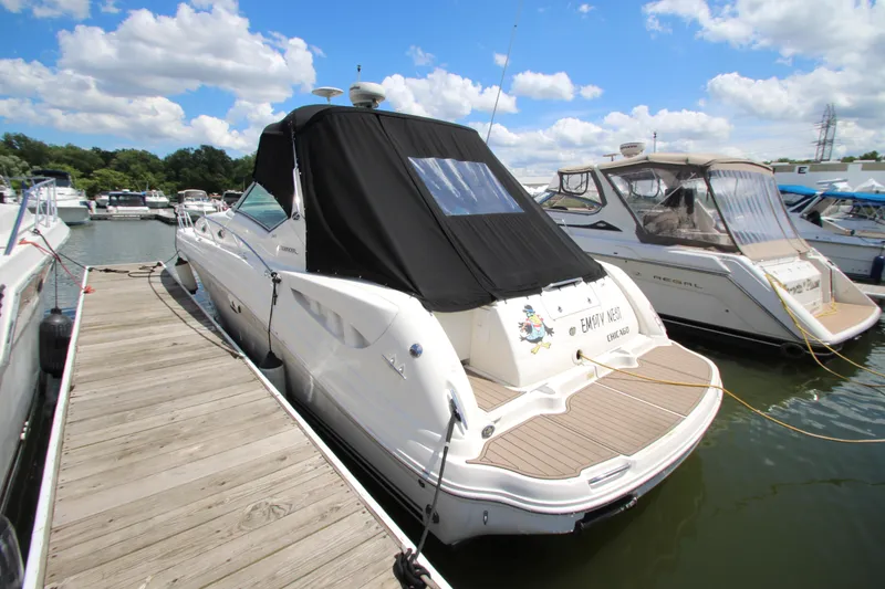 The Image of A 2005 Sea Ray 340 Sundancer docked, featuring a black canopy. - 2