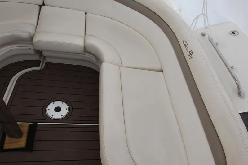 Slide: The Image of 2005 Sea Ray 340 Sundancer boat interior with white cushioned seating and wood flooring. - 27