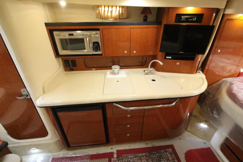 Slide: The Image of 2005 Sea Ray 340 Sundancer galley with microwave, sink, and TV. - 7
