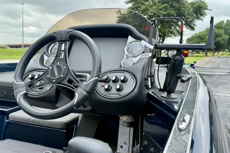 Slide: The Image of 2023 Triton 18 TrX boat dashboard with steering wheel and control panel. - 3