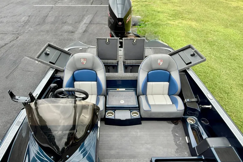 Slide: The Image of 2023 Triton 18 TrX boat interior with dual seats and storage compartments open. - 13