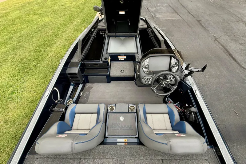 Slide: The Image of 2023 Triton 18 TrX boat interior with dual seats, steering console, and storage compartments. - 12