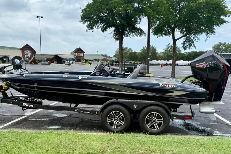 Slide: The Image of 2023 Triton 18 TrX boat on trailer in parking lot, featuring sleek design and Mercury Pro XS engine. - 7