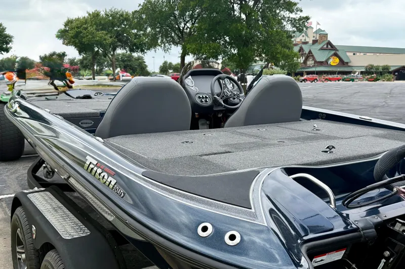 Slide: The Image of 2023 Triton 18 TrX boat with sleek design and dual seating in a parking lot. - 6
