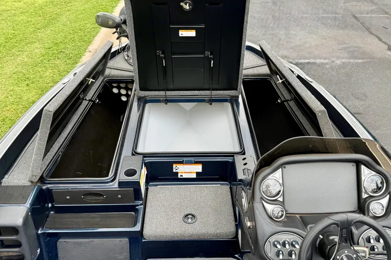 Slide: The Image of 2023 Triton 18 TrX boat interior with open storage compartments and control panel. - 10