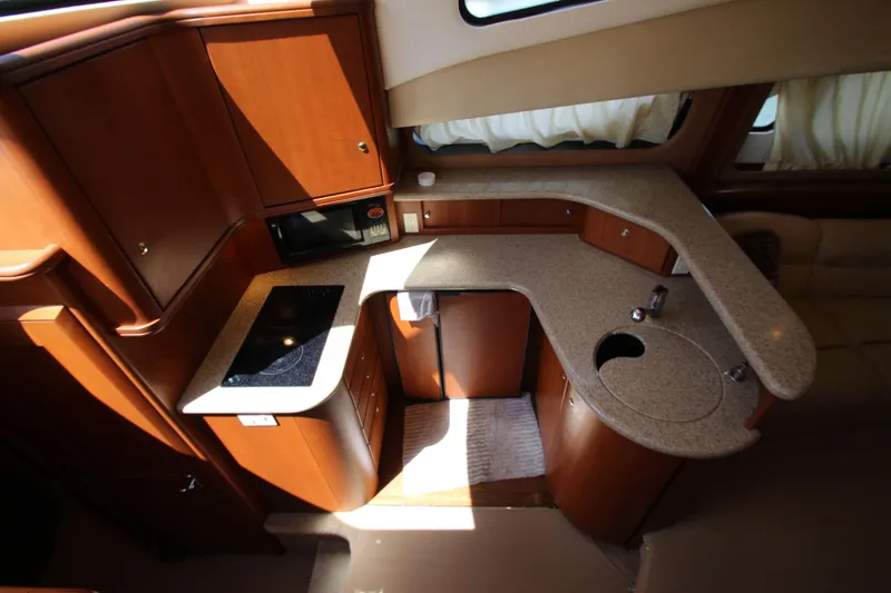 Slide: The Image of Interior of 2006 Silverton 38 Sport Bridge yacht kitchen with wood cabinetry and countertops. - 12