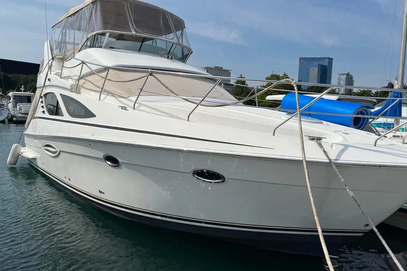The Image of 2006 Silverton 38 Sport Bridge yacht docked in marina, featuring sleek design and spacious deck. - 2