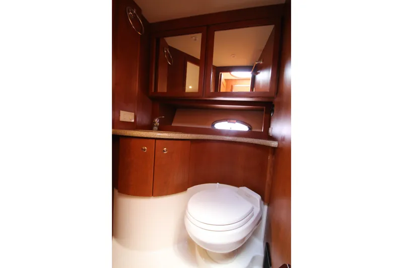 Slide: The Image of 2006 Silverton 38 Sport Bridge yacht bathroom with wood cabinetry and modern fixtures. - 20