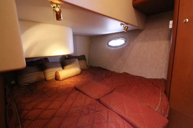 Slide: The Image of Cozy cabin interior of 2006 Silverton 38 Sport Bridge with plush bedding and ambient lighting. - 24