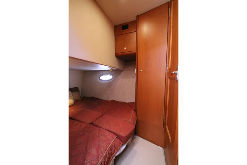 Slide: The Image of 2006 Silverton 38 Sport Bridge cabin with cozy bed and wooden cabinetry. - 25