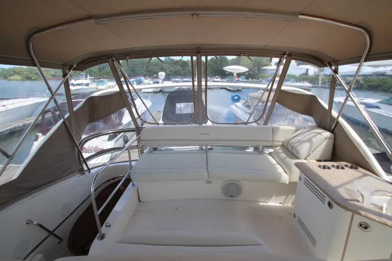 Slide: The Image of 2006 Silverton 38 Sport Bridge interior with seating and marina view. - 38
