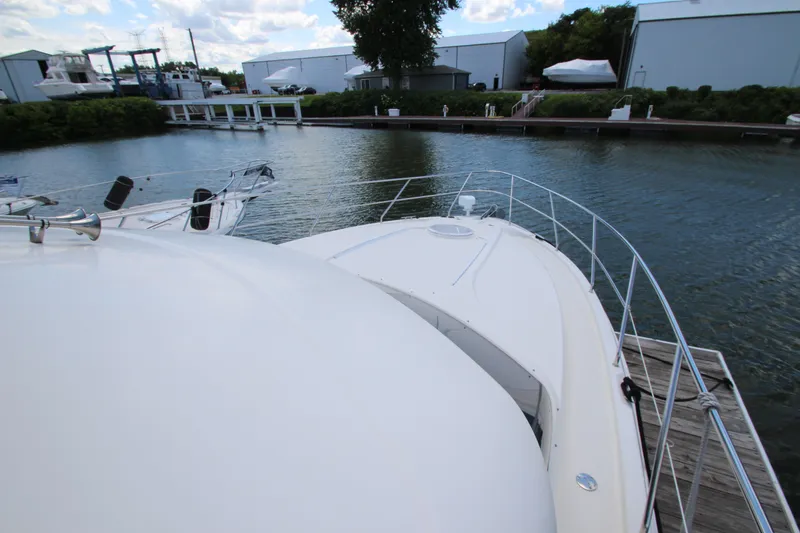 Slide: The Image of 2006 Silverton 38 Sport Bridge yacht docked at a marina, surrounded by calm waters. - 43