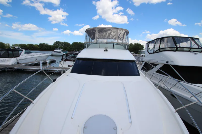 Slide: The Image of 2006 Silverton 38 Sport Bridge yacht docked at marina under blue sky. - 46