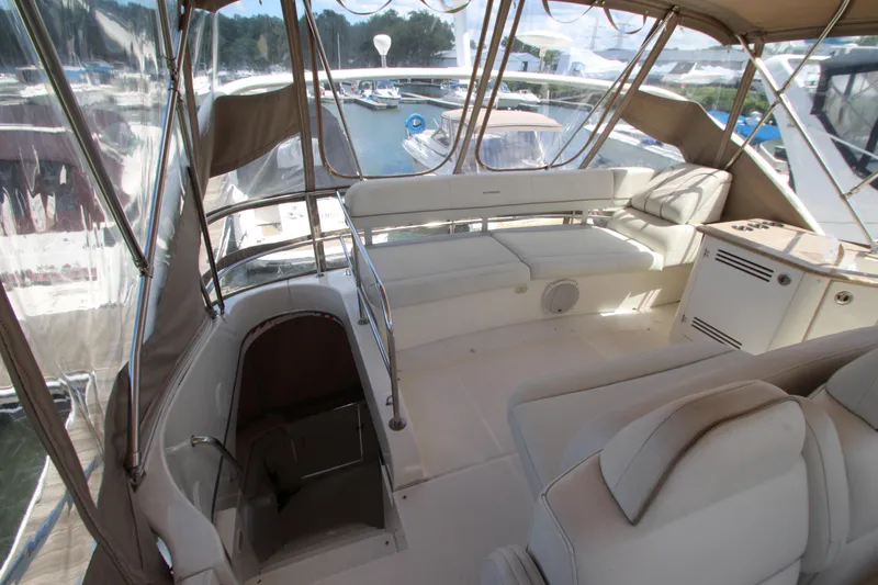 Slide: The Image of 2006 Silverton 38 Sport Bridge interior with seating and helm, docked at marina. - 49