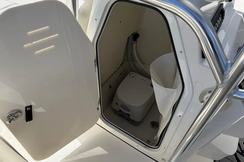 Slide: The Image of 2026 Key West 203 FS boat interior with open compartment and portable toilet. - 30