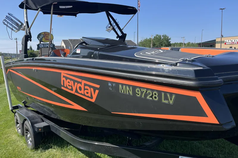 Slide: The Image of 2018 Heyday WT-2 boat with orange accents on a trailer, parked on grass. - 4
