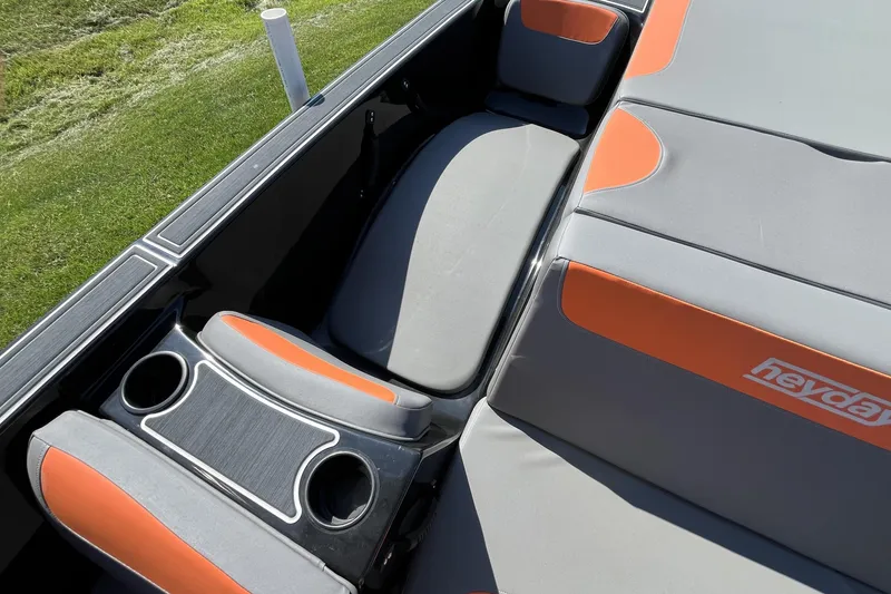Slide: The Image of 2018 Heyday WT-2 boat interior with gray and orange seating, cup holders, and logo. - 19
