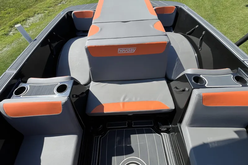 Slide: The Image of 2018 Heyday WT-2 boat interior with gray and orange seating, cup holders, and sleek design. - 18