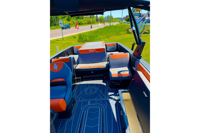 Slide: The Image of 2018 Heyday WT-2 boat interior with orange and gray seating, parked on grass. - 9