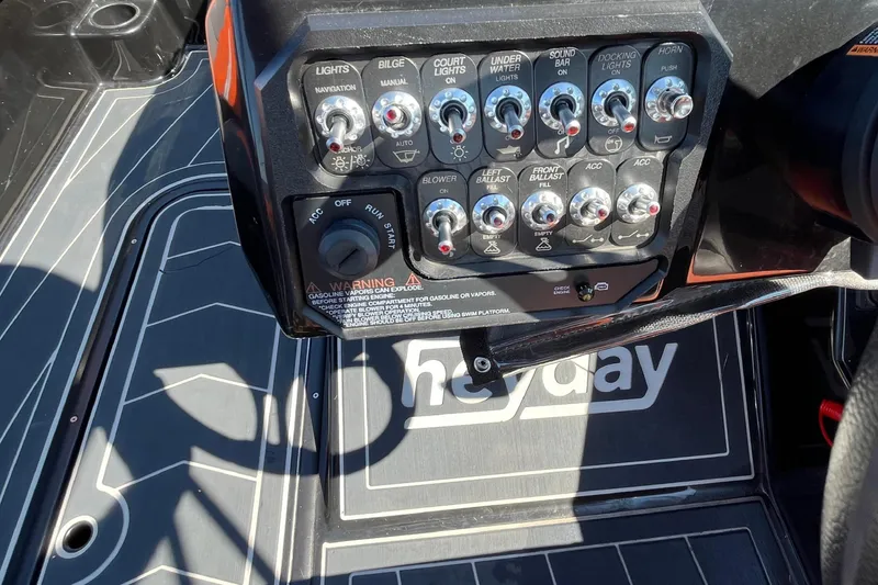 Slide: The Image of Control panel of a 2018 Heyday WT-2 boat with various switches and warning label. - 14